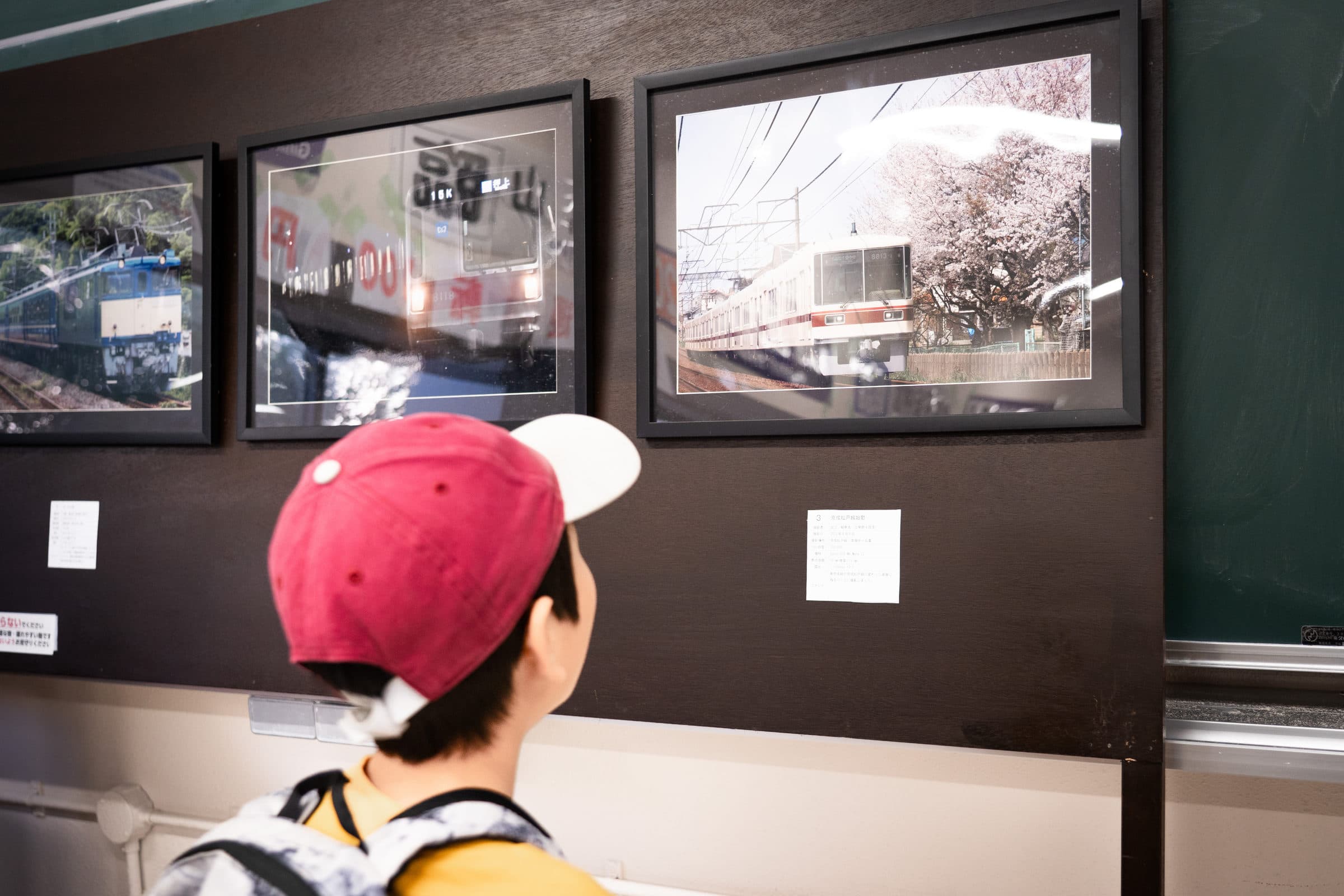 A child absorbed in an indoor photo exhibition project