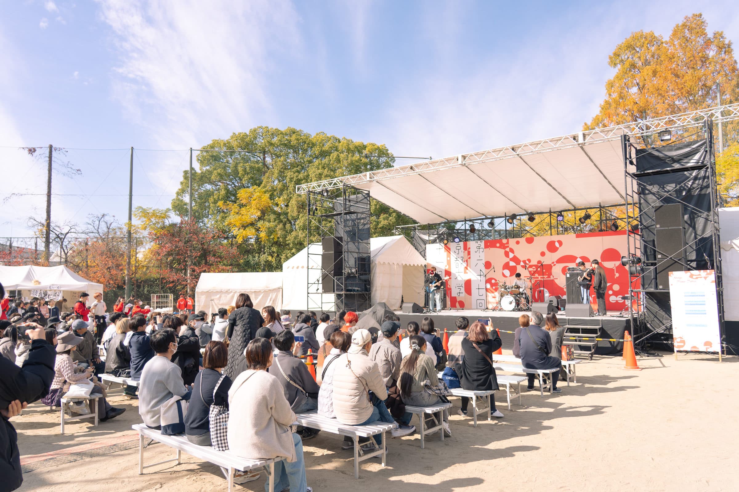 青空の下、おまつり広場ステージの演奏を楽しむ大勢の観客